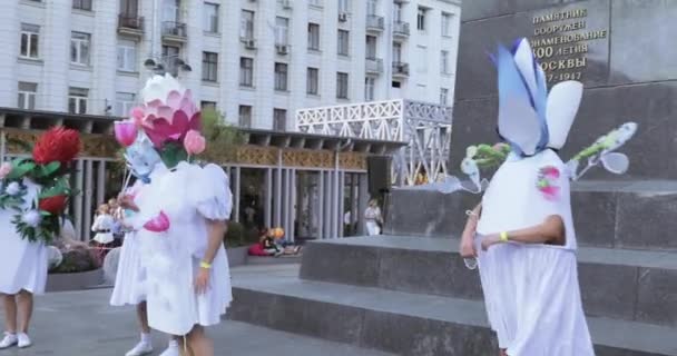 Танцоры на ходулях в костюмах красочных больших цветов — стоковое видео