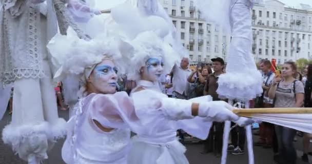 Dancers on stilts in suits of white elves or butterflies with inflatable balls — Stock Video