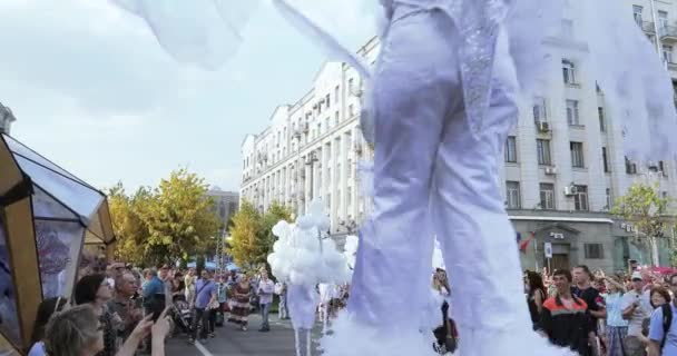 Bailarinas sobre zancos en trajes de elfos blancos o mariposas con bolas inflables — Vídeo de stock