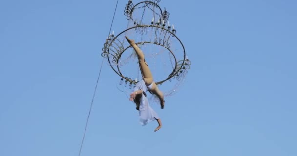 Lány acrobat fehér ruha a levegőben fent az utcán egy nagy csillár a kötélen — Stock videók