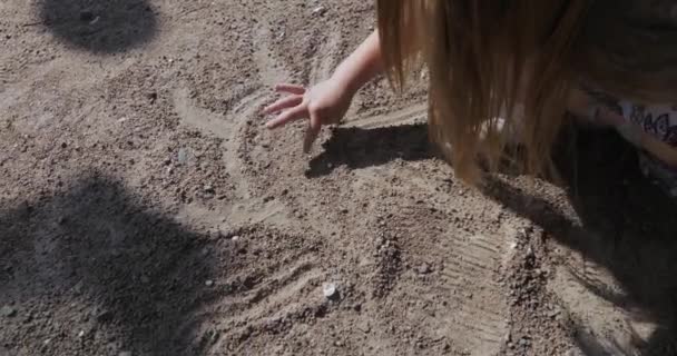 Mädchen zeichnet in den Sand — Stockvideo