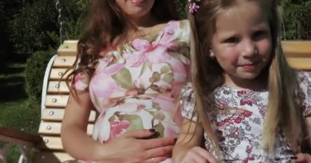 Дівчинка на гойдалці з батьками — стокове відео