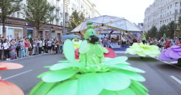 Dansare på styltor i dräkter av färgglada stora blommor — Stockvideo