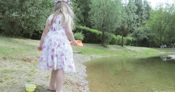 Fille enfant sur le rivage d'un étang — Video