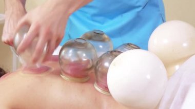 Masör adam kavanozlu kıza masaj yapıyor.