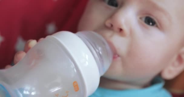 Niño aprende a beber de un biberón — Vídeos de Stock