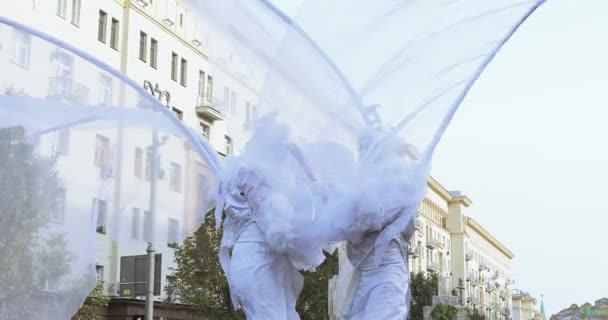 Bailarinas sobre zancos en trajes de elfos blancos o mariposas con bolas inflables — Vídeo de stock