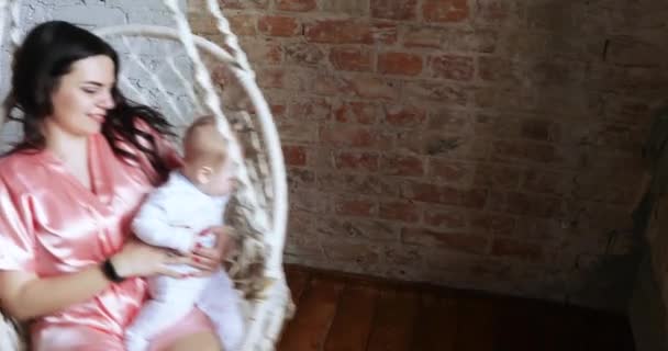 Maman avec un enfant dans une chaise suspendue — Video