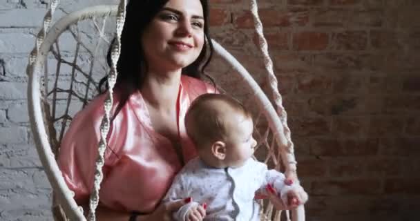 Maman avec un enfant dans une chaise suspendue — Video