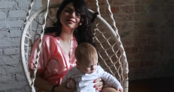 Мама с ребенком в висящем кресле — стоковое видео