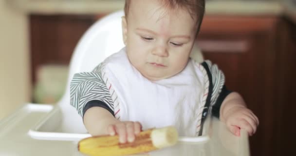 Малыш ест банан — стоковое видео