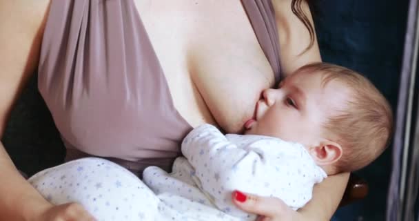 A young woman feeds the baby — Stock Video