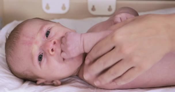 Moeder zet op een luier baby — Stockvideo