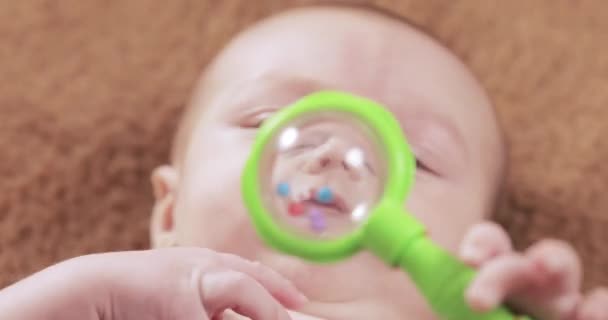 Ребенок с погремушкой — стоковое видео