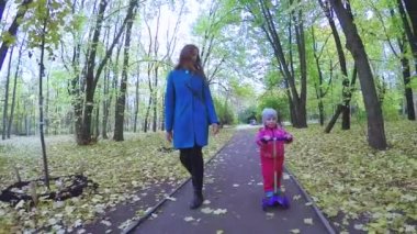 Anne ve kız motosiklete biniyor.