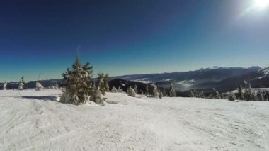 Kar dağlarından kayak yapan kadın.