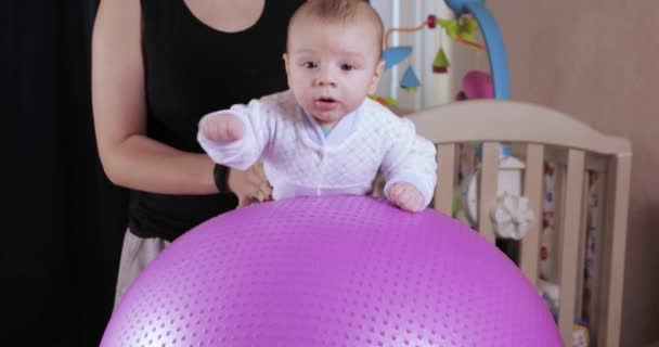 Babyjongen op de fitness bal — Stockvideo