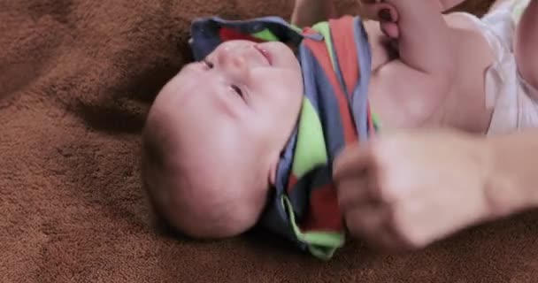 Mutter kleidet das Baby ein — Stockvideo