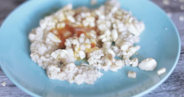 Harina de avena en un plato con mermelada — Vídeo de stock