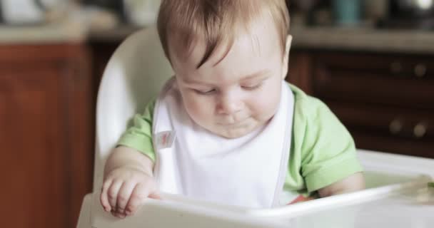 Menino em uma cadeira infantil — Vídeo de Stock