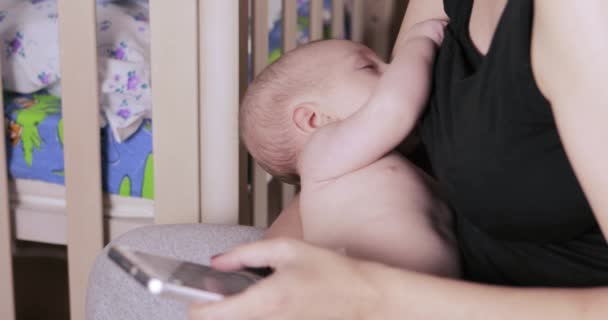 Mère allaitante avec smartphone — Video