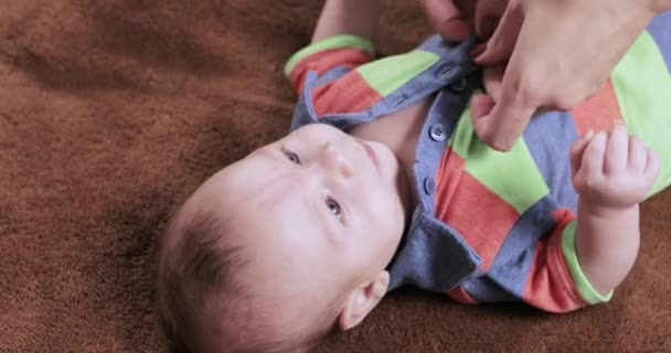 Мама одевает ребенка — стоковое видео