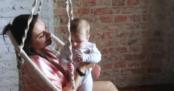 Maman avec un enfant dans une chaise suspendue — Video