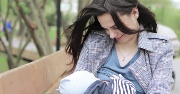Mom breastfeeds a child in the park — Stock Video