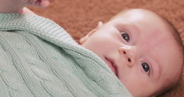 Baby onder de gebreide deken — Stockvideo