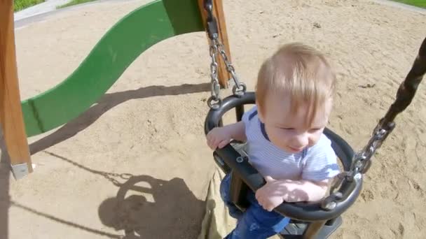 Малыш на качелях — стоковое видео