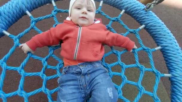 Αγόρι βόλτα με το παιδί σε μια κούνια — Αρχείο Βίντεο