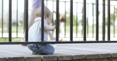 Çocuk çite yapışmış.