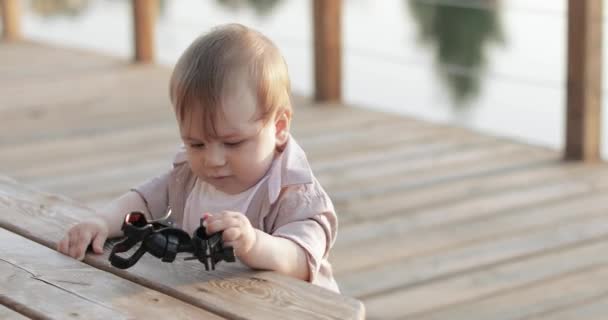 Un niño cerca del banco de madera — Vídeos de Stock