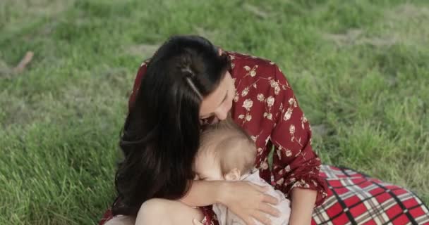 Дитячий хлопчик кусає матір на пікніку — стокове відео