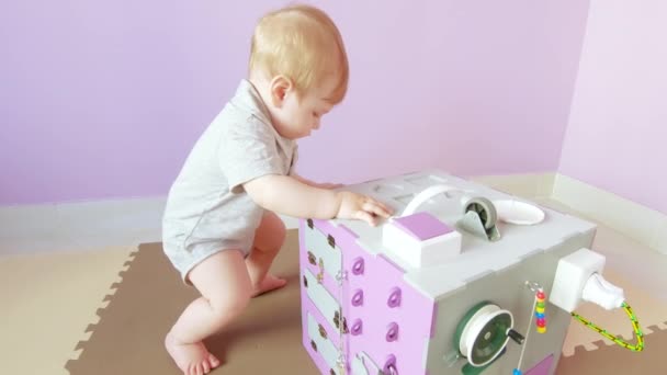 Baby spielt mit geschäftigem Würfel — Stockvideo