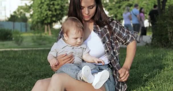 Mamá con un niño en la orilla del estanque — Vídeos de Stock