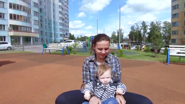 Mom and son ride on a swing — Stock Video