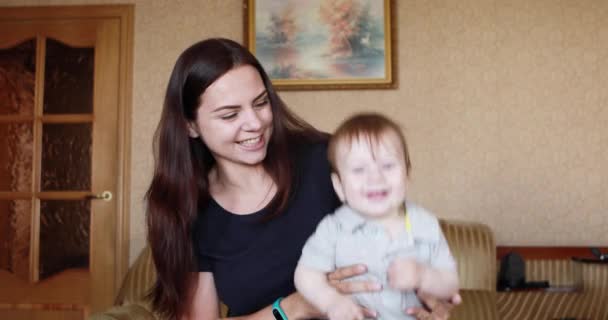 Een jonge moeder met een baby lach — Stockvideo