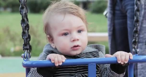 Babyjongen op een schommel — Stockvideo