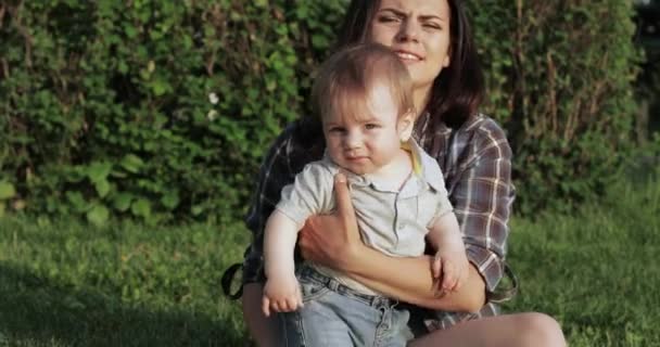 Мама с ребенком на газоне — стоковое видео