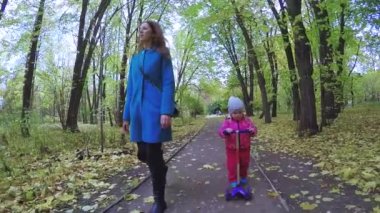 Anne ve kız motosiklete biniyor.