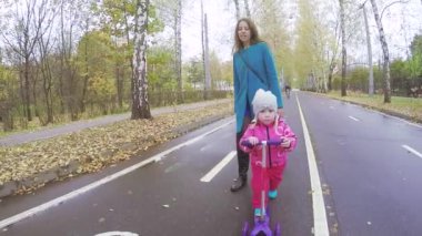 Anne ve kız motosiklete biniyor.