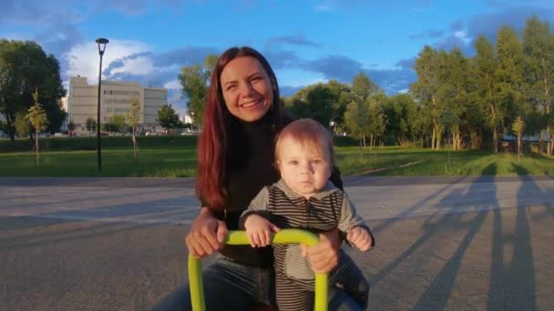 Мама з дитиною на залізній гойдалки — стокове відео