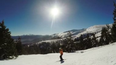 Kar dağlarından kayak yapan kadın.