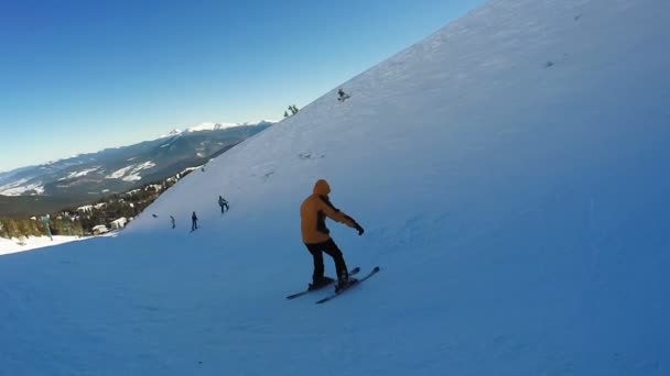 Человек спускается на лыжах со снежных гор — стоковое видео