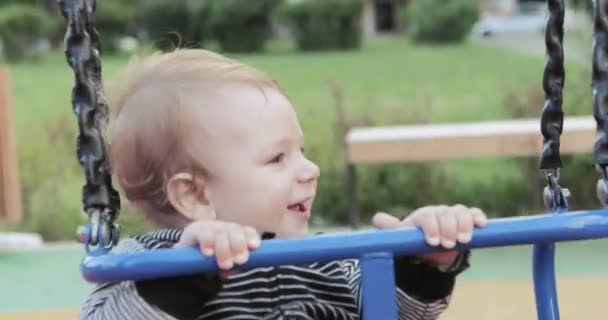 Babyjongen op een schommel — Stockvideo