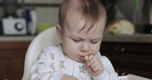 Хлопчик їсть яблуко за столом — стокове відео
