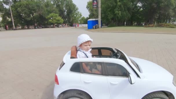 Chico conduciendo un coche de juguete — Vídeo de stock