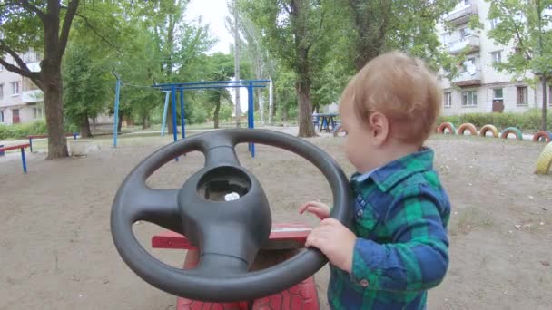 Мальчик с игрушечным рулем — стоковое видео