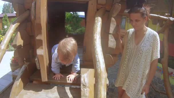 Niño en una casa de madera — Vídeo de stock